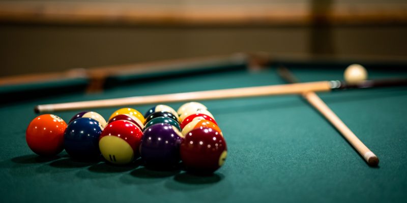 A closeup of billiard balls and sticks on the p table